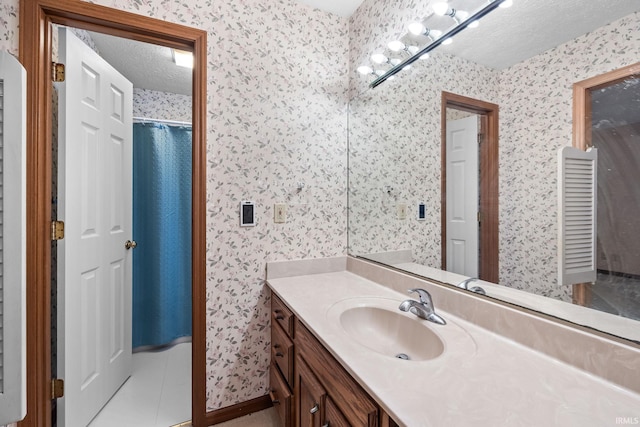 bathroom featuring tile patterned floors, vanity, and a textured ceiling