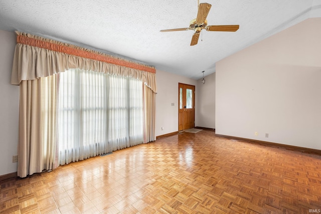 unfurnished room with ceiling fan, a textured ceiling, lofted ceiling, and light parquet flooring