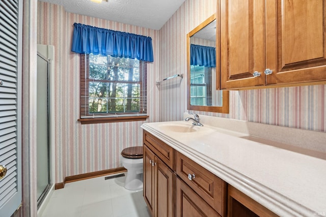 bathroom featuring vanity, a textured ceiling, a shower with shower door, tile patterned floors, and toilet