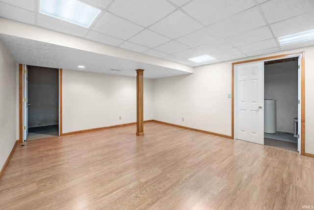 basement featuring a paneled ceiling and light hardwood / wood-style floors