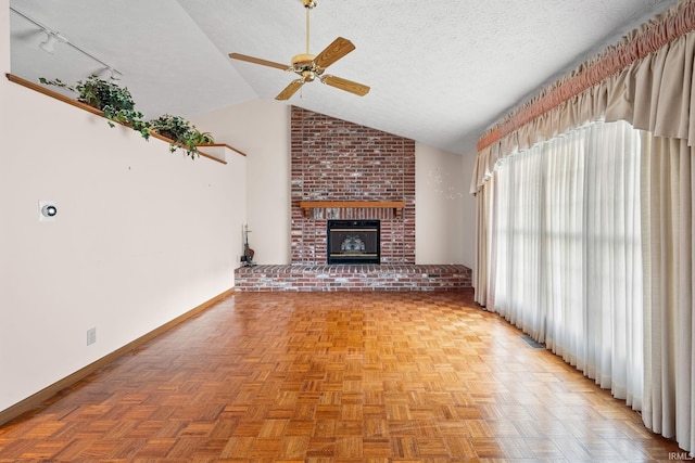 unfurnished living room with lofted ceiling, a brick fireplace, light parquet flooring, and a textured ceiling