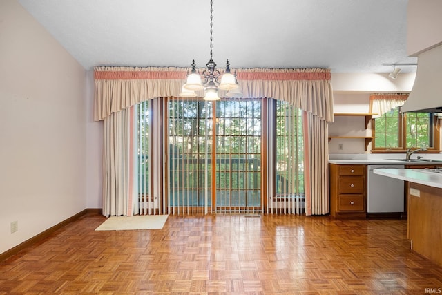 kitchen with a textured ceiling, plenty of natural light, and stainless steel dishwasher