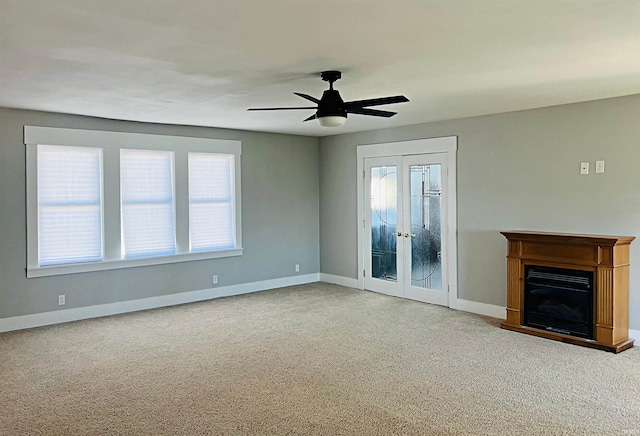 unfurnished living room with ceiling fan, french doors, and carpet flooring