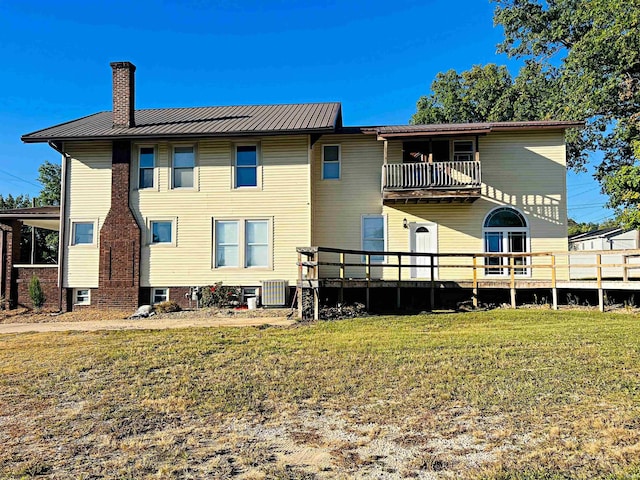 back of property featuring a balcony and a lawn