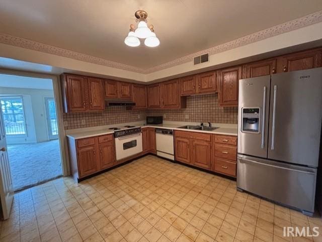 kitchen featuring white appliances, visible vents, light countertops, and a sink