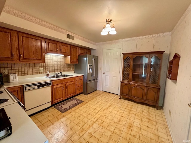 kitchen featuring stainless steel fridge, sink, backsplash, a chandelier, and dishwasher