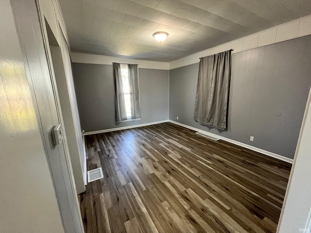 spare room with dark hardwood / wood-style flooring