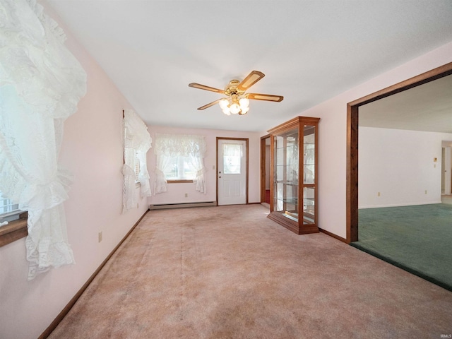 carpeted empty room with a baseboard heating unit and ceiling fan