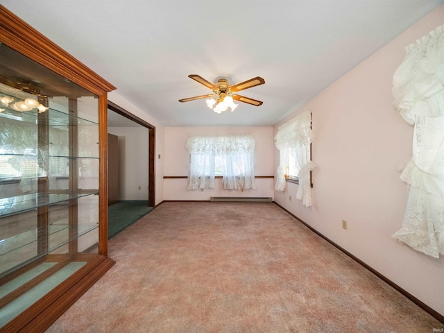 carpeted spare room featuring baseboard heating and ceiling fan