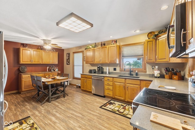 kitchen featuring ceiling fan, appliances with stainless steel finishes, light wood-type flooring, and sink