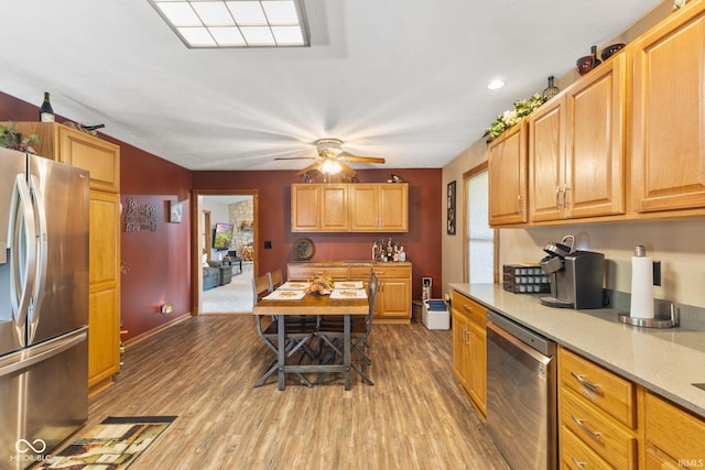 kitchen with light hardwood / wood-style floors, ceiling fan, and stainless steel appliances