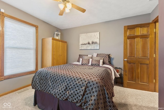 bedroom with ceiling fan, a textured ceiling, and carpet flooring