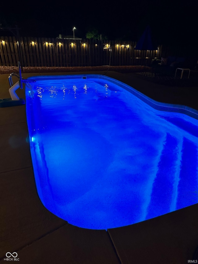 view of pool at twilight