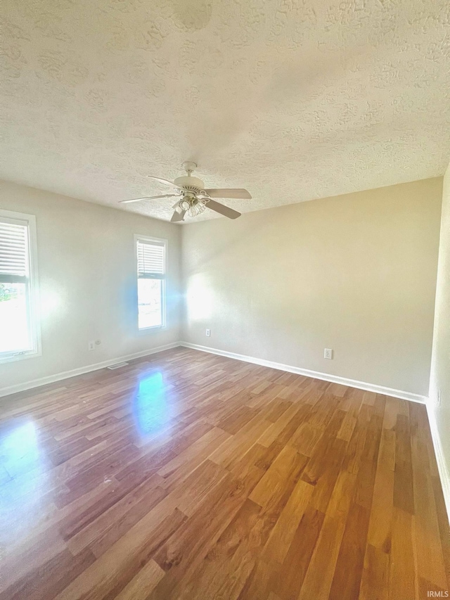 unfurnished room featuring a textured ceiling, wood-type flooring, and ceiling fan