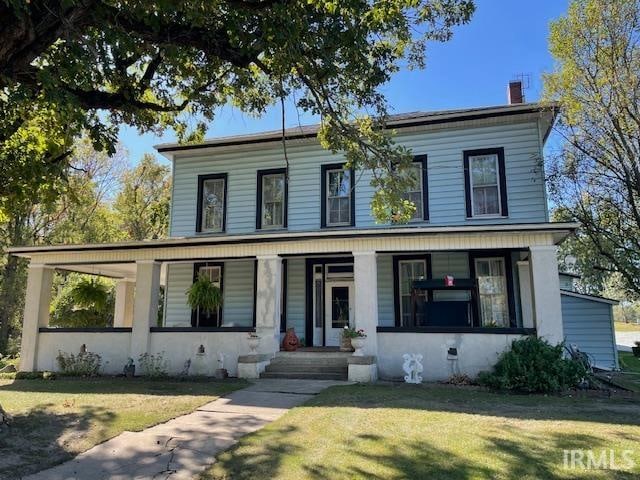 view of front of property with covered porch and a front lawn