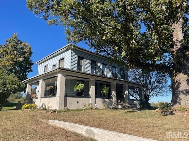 view of front of property with a porch and a front lawn