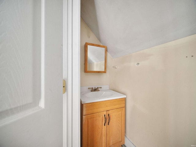 bathroom with vaulted ceiling and vanity