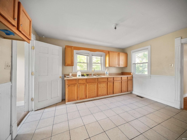 kitchen with a wealth of natural light, sink, and light tile patterned floors