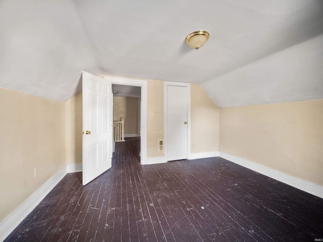 additional living space with vaulted ceiling and dark wood-type flooring