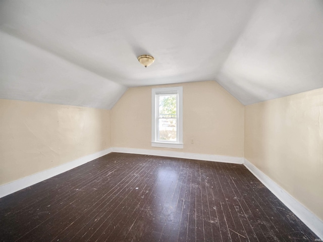 additional living space with vaulted ceiling and dark hardwood / wood-style flooring