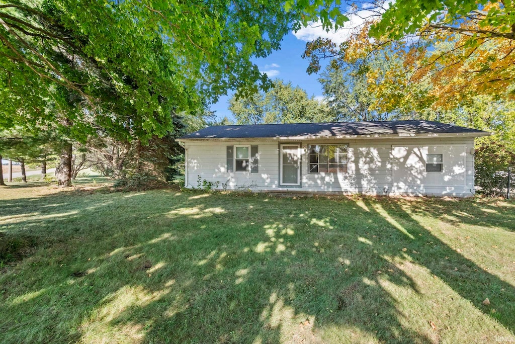 rear view of house featuring a yard