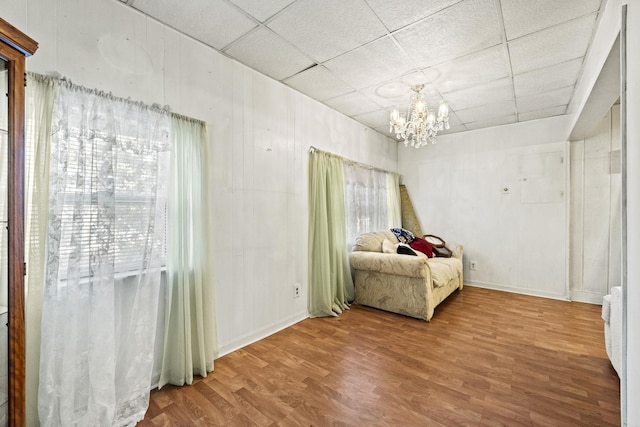 6885 N 315 E, Howe, IN 46746 - bedroom featuring baseboards, an inviting chandelier, a paneled ceiling, and wood finished floors