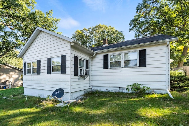 rear view of house with cooling unit and a yard