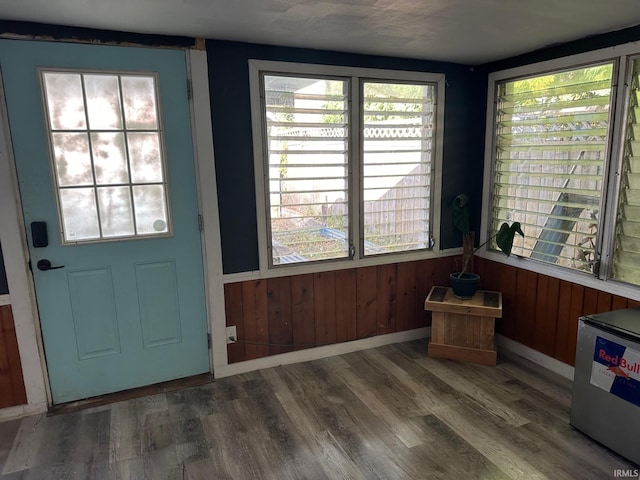 doorway with wood walls and dark hardwood / wood-style flooring