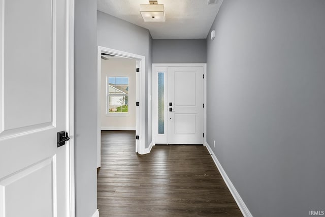 hall with dark hardwood / wood-style floors and a textured ceiling