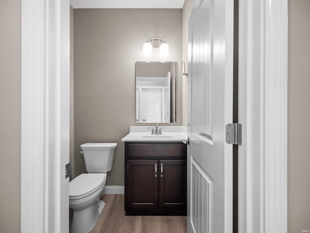 bathroom featuring wood-type flooring, vanity, and toilet