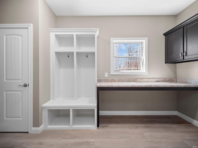 mudroom featuring built in desk and light hardwood / wood-style floors