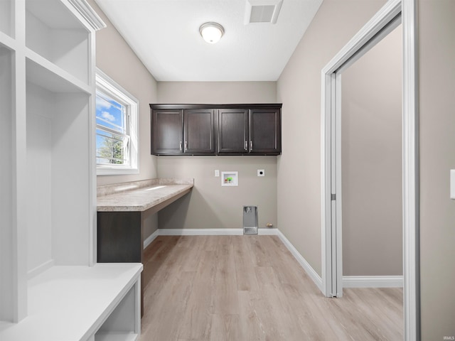 washroom featuring washer hookup, cabinets, light hardwood / wood-style floors, and hookup for an electric dryer