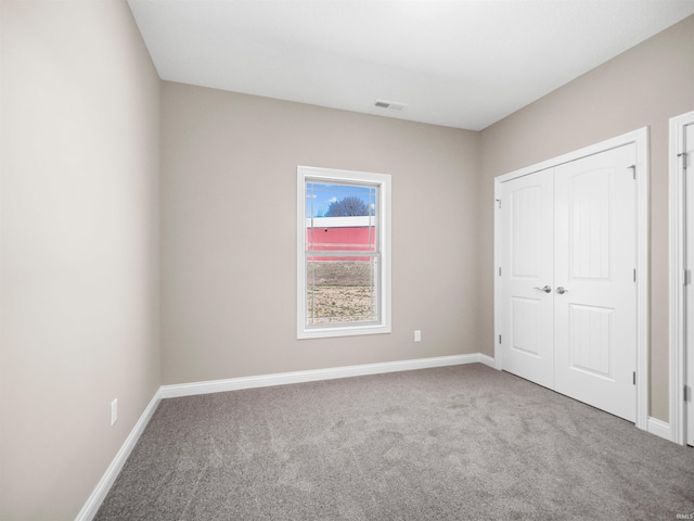 unfurnished bedroom with carpet floors and a closet