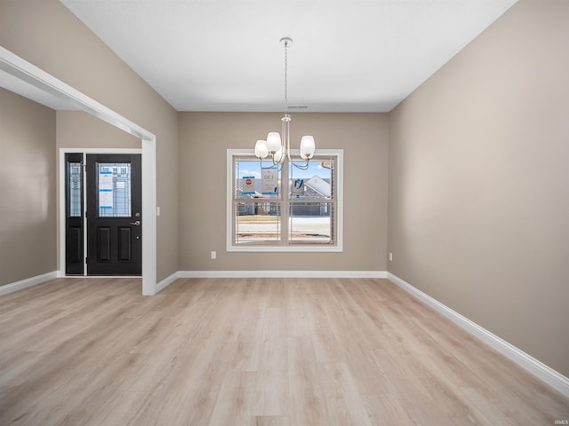 interior space with a healthy amount of sunlight, a chandelier, and light hardwood / wood-style floors