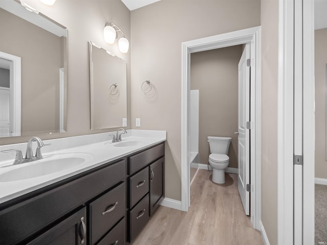 bathroom with hardwood / wood-style flooring, vanity, and toilet