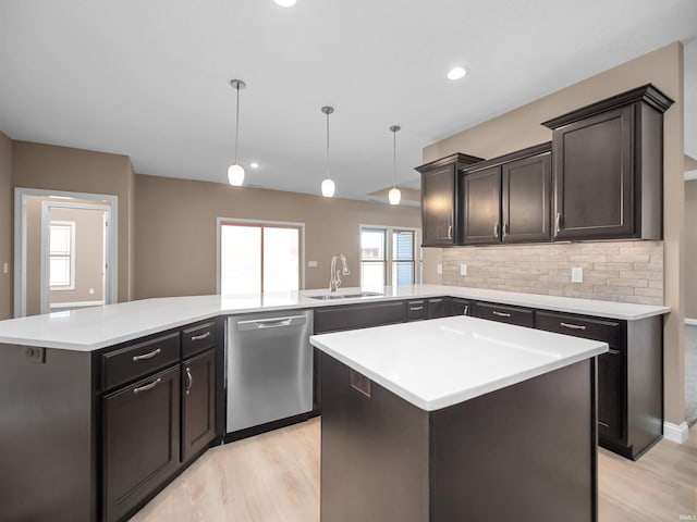 kitchen with a kitchen island, sink, kitchen peninsula, hanging light fixtures, and stainless steel dishwasher