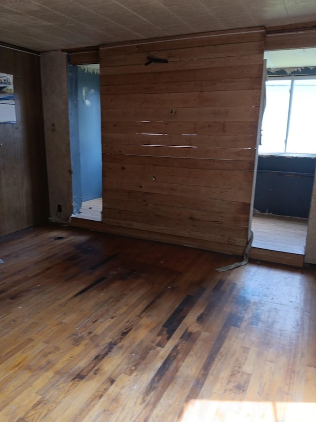 empty room featuring hardwood / wood-style flooring and wooden walls