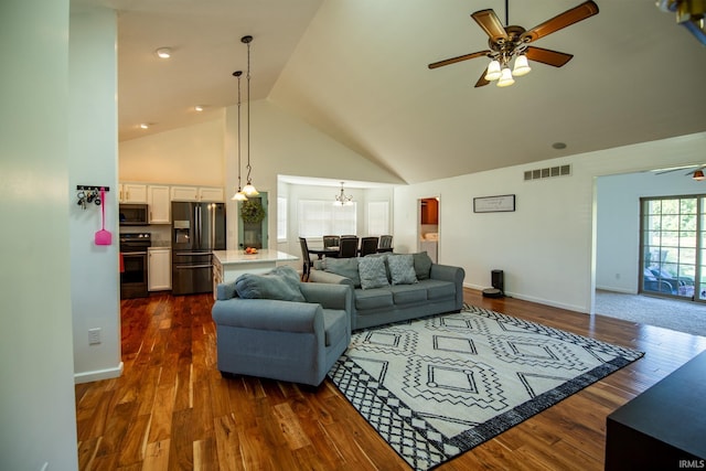 living room with ceiling fan with notable chandelier, high vaulted ceiling, and dark hardwood / wood-style flooring