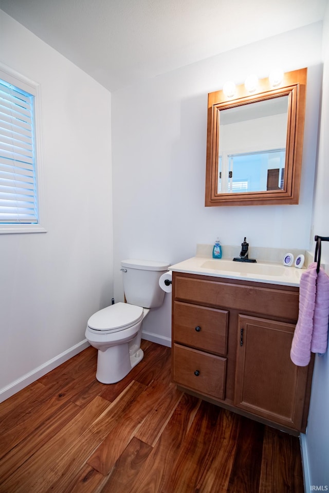 bathroom with hardwood / wood-style flooring, toilet, and vanity