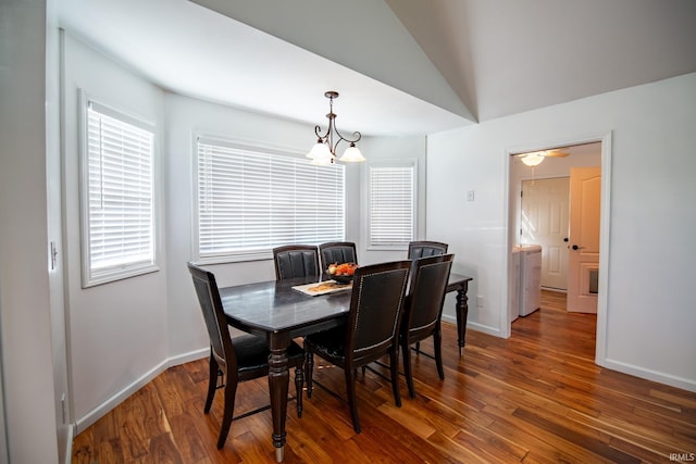 dining area featuring dark wood-type flooring, lofted ceiling, and a chandelier