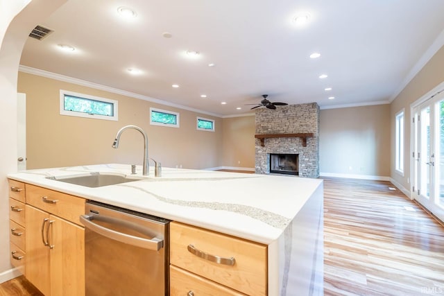 kitchen with dishwasher, a fireplace, crown molding, and light hardwood / wood-style flooring