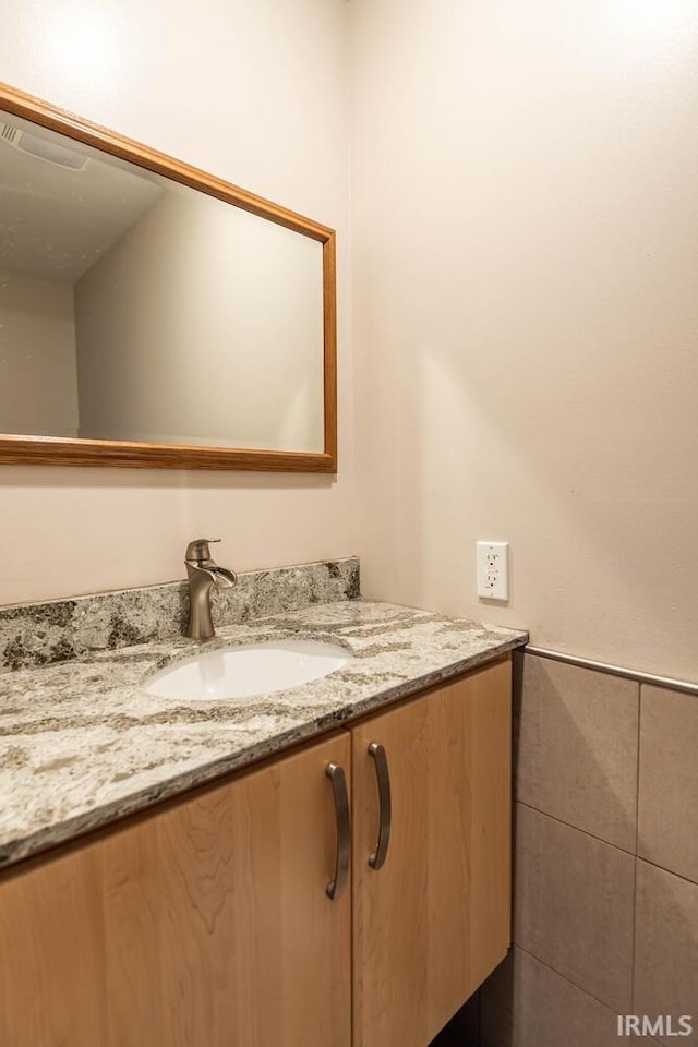 bathroom featuring tile walls and vanity