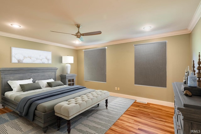 bedroom with ornamental molding, ceiling fan, and light hardwood / wood-style flooring