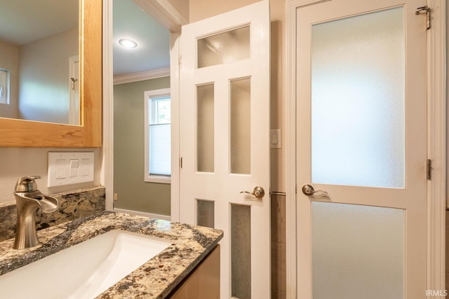 bathroom with vanity and ornamental molding