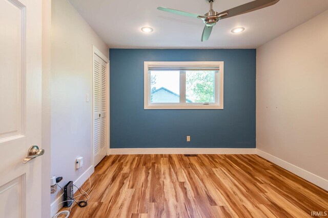 unfurnished bedroom featuring a closet, light hardwood / wood-style floors, and ceiling fan