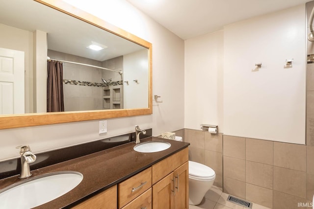 bathroom featuring vanity, a shower with curtain, tile walls, tile patterned flooring, and toilet