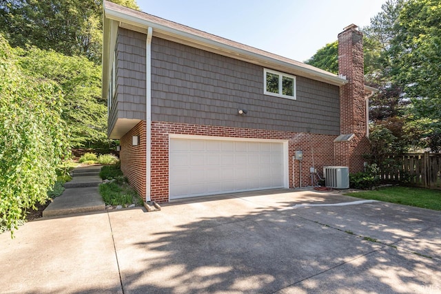 view of front of property featuring a garage and central AC unit