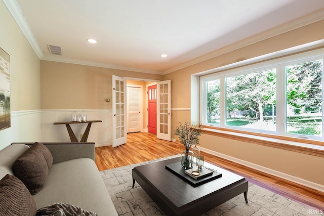 living room with french doors, crown molding, and hardwood / wood-style floors