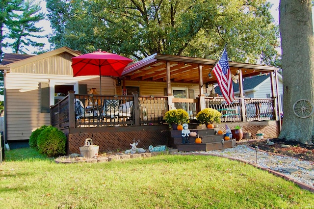 back of house featuring a deck and a lawn