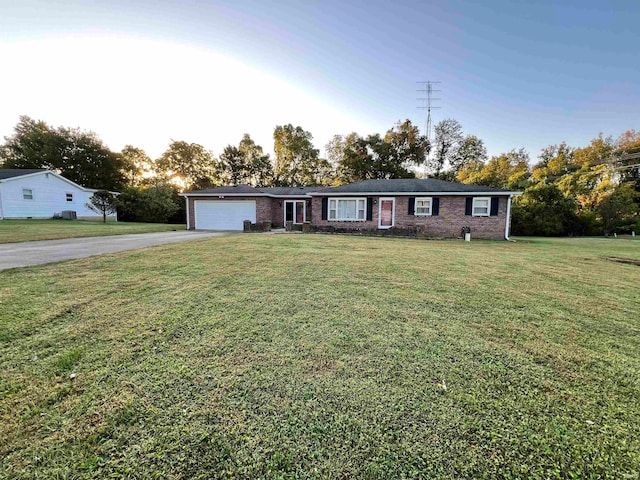 ranch-style home featuring a garage and a front lawn